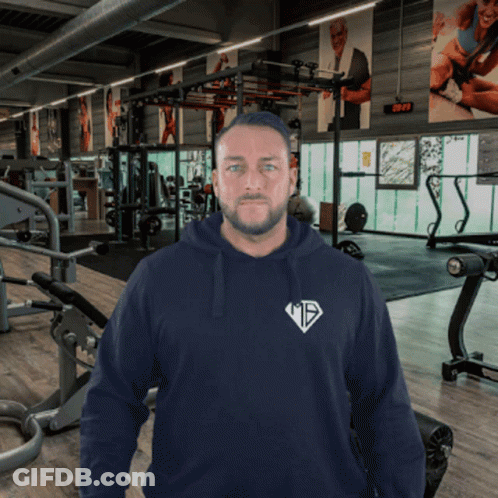 A Man In A Gym Wearing A Hoodie That Says ' Mts ' On It GIF