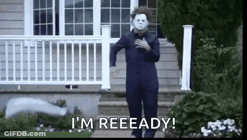 A Man In A Halloween Costume Is Standing In Front Of A House With His Hand On His Chest . GIF