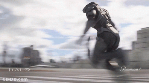 A Man In A Halo Costume Is Running On A Road GIF