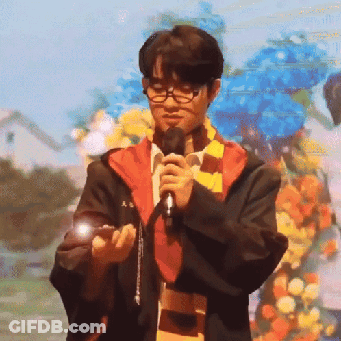A Man In A Harry Potter Outfit Is Holding A Microphone GIF