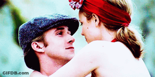 A Man In A Hat And A Woman In A Red Headband Are Hugging GIF