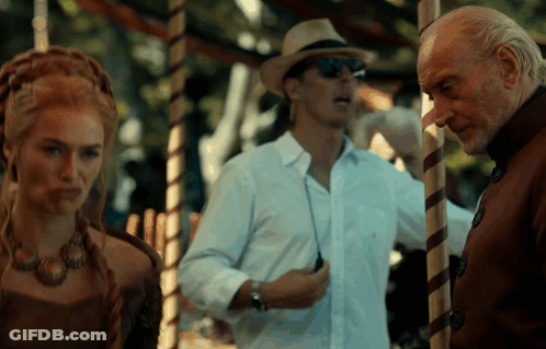 A Man In A Hat And Sunglasses Stands Next To A Woman GIF
