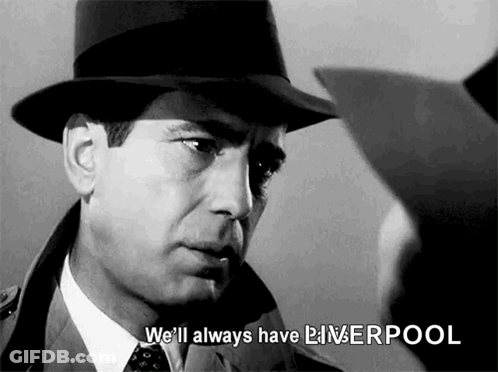 A Man In A Hat And Tie Is Talking To Another Man In A Suit . GIF