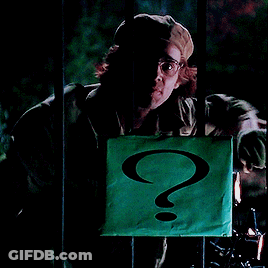 A Man In A Hat Holds A Green Sign With A Question Mark On It GIF