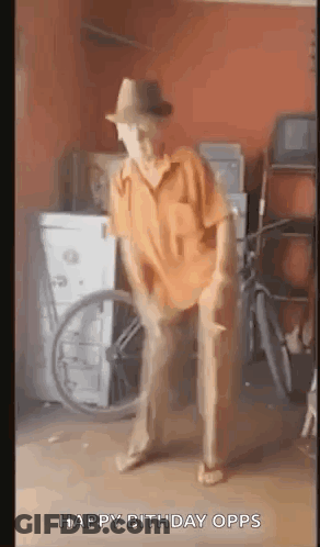 A Man In A Hat Is Dancing In A Garage With A Wheelchair In The Background . GIF