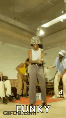 A Man In A Hat Is Dancing In A Room With Other People And The Word Funky Is On The Screen . GIF