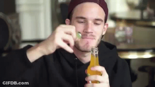A Man In A Hat Is Drinking From A Bottle Of Beer . GIF