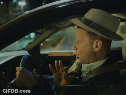 A Man In A Hat Is Driving A Car And Making A Funny Face GIF