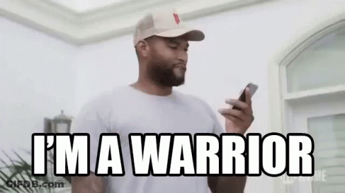 A Man In A Hat Is Holding A Cell Phone And Says `` I 'M A Warrior '' . GIF