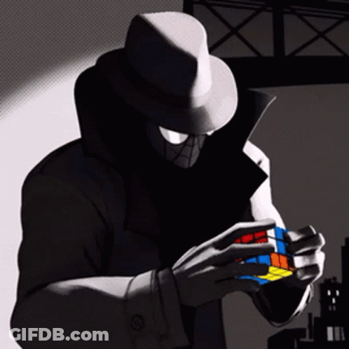 A Man In A Hat Is Holding A Colorful Rubik 'S Cube In His Hands GIF