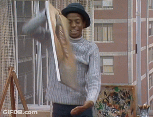 A Man In A Hat Is Holding A Painting That Says ' A ' On It GIF