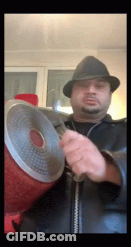 A Man In A Hat Is Holding A Pot GIF