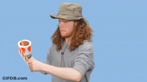 A Man In A Hat Is Holding A Roll Of Tape That Says Labels Are Stickers On It GIF