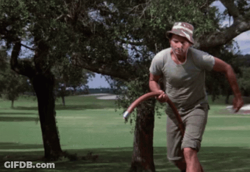 A Man In A Hat Is Running On A Golf Course With A Frisbee In His Hand GIF