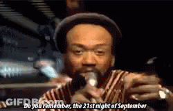 A Man In A Hat Is Singing Into A Microphone And Saying Do You Remember The 21St Night Of September . GIF