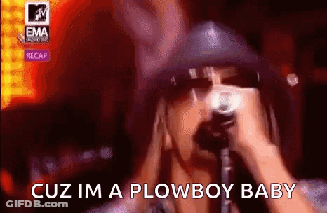 A Man In A Hat Is Singing Into A Microphone . GIF