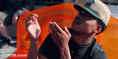 A Man In A Hat Is Sitting On An Orange Raft GIF