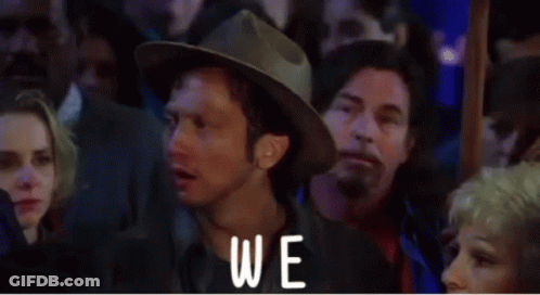 A Man In A Hat Is Standing In Front Of A Crowd And The Word Again Is On The Screen GIF