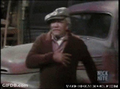 A Man In A Hat Is Standing In Front Of A Truck That Says Nick Nite On It GIF