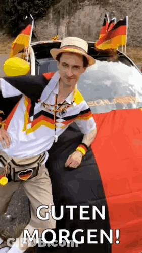 A Man In A Hat Is Standing Next To A Car With A German Flag On The Back . GIF