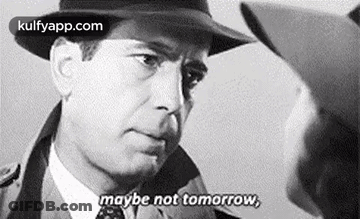 A Man In A Hat Is Talking To Another Man In A Suit And Tie . GIF