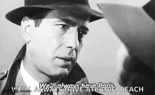 A Man In A Hat Is Talking To Another Man With The Words We 'Ll Always Have Atlantic Beach Below Him GIF