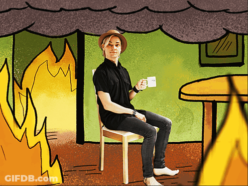 A Man In A Hat Sits In A Chair Holding A Cup Of Coffee GIF