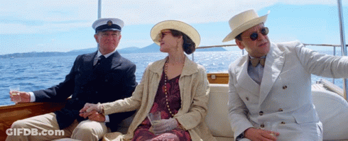 A Man In A Hat Sits Next To A Woman On A Boat GIF