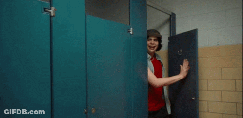 A Man In A Hat Stands In A Bathroom Stall GIF