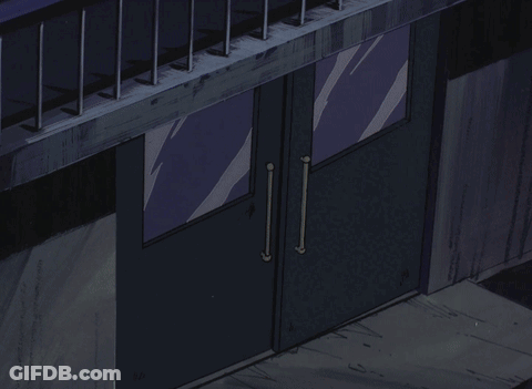 A Man In A Hat Stands In A Doorway GIF