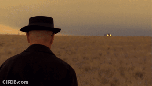 A Man In A Hat Stands In A Field Looking At A Car GIF