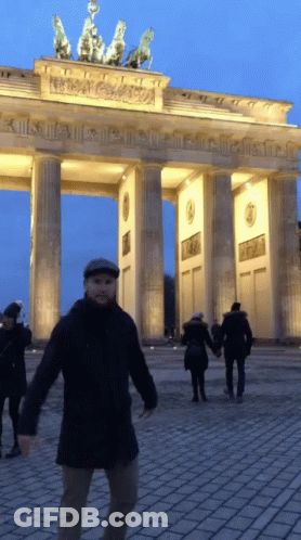 Man In Hat In Front Of Columned Building GIF