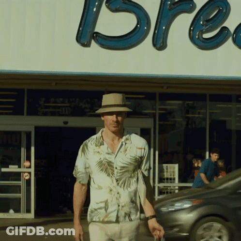 A Man In A Hat Stands In Front Of A Store That Says Bre GIF