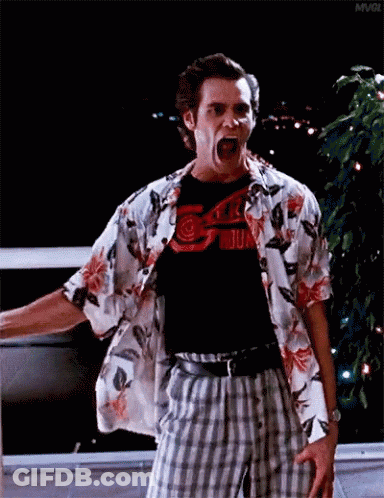 A Man In A Hawaiian Shirt And Plaid Shorts Is Screaming With His Mouth Open . GIF