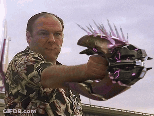 A Man In A Hawaiian Shirt Is Holding A Purple Object With Spikes On It GIF