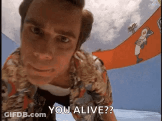 A Man In A Hawaiian Shirt Is Looking At The Camera And Says `` You Alive ? '' GIF