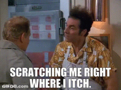 A Man In A Hawaiian Shirt Is Scratching Another Man In A Kitchen GIF
