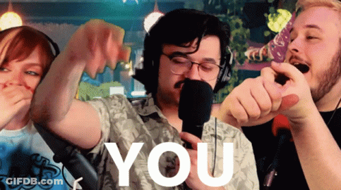 A Man In A Hawaiian Shirt Is Singing Into A Microphone And The Word You Is Visible Behind Him GIF