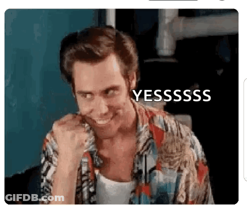 A Man In A Hawaiian Shirt Is Smiling And Making A Funny Face With His Fist In His Mouth . GIF