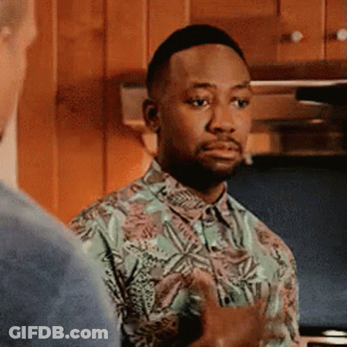 A Man In A Hawaiian Shirt Is Standing In A Kitchen Talking To Another Man . GIF
