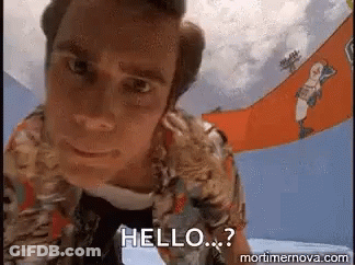 A Man In A Hawaiian Shirt Is Standing In Front Of A Sign That Says Hello . GIF