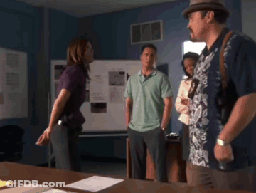 A Man In A Hawaiian Shirt Stands In A Room With Other People GIF
