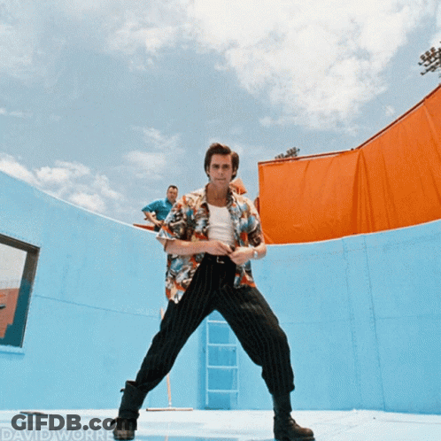 A Man In A Hawaiian Shirt Stands In Front Of A Blue Wall With David Worrell Written On The Bottom Right GIF