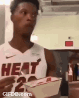 A Man In A Heat Jersey Is Holding A Basket Of Food . GIF