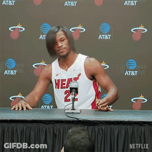 A Man In A Heat Jersey Is Sitting At A Table GIF