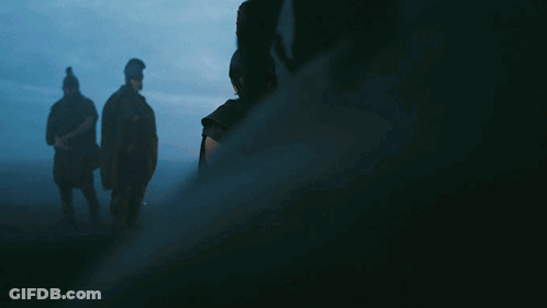 A Man In A Helmet Holds A Sword In His Hand GIF