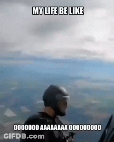 A Man In A Helmet Is Flying A Parachute In The Air . GIF