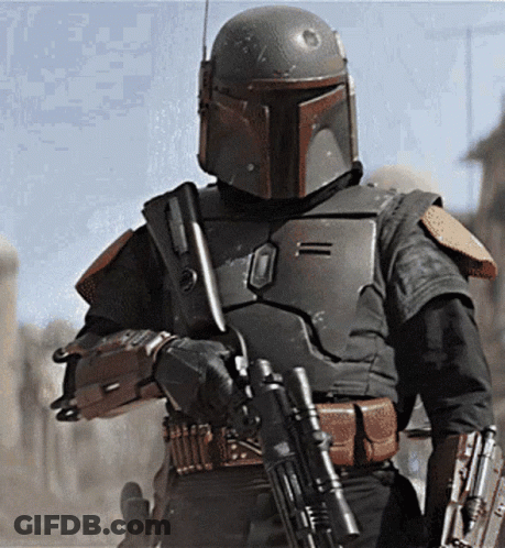 A Man In A Helmet Is Holding A Gun In His Hand GIF
