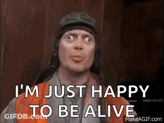 A Man In A Helmet Is Making A Funny Face And Says `` I 'M Just Happy To Be Alive '' . GIF