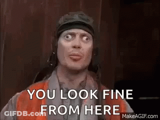 A Man In A Helmet Is Making A Funny Face And Says `` You Look Fine From Here '' . GIF